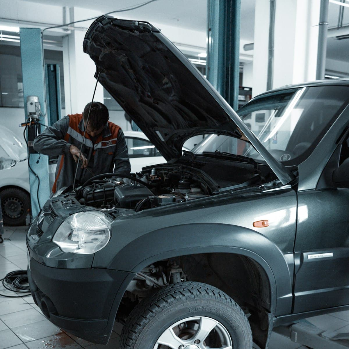 A car raised on the ramp with its bonnet open during an MOT test